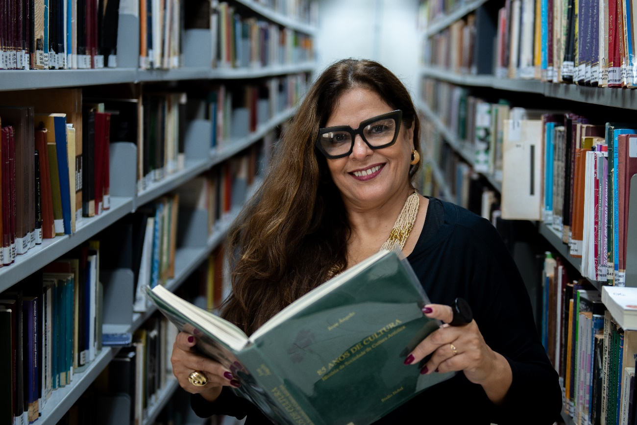 Alessandra Donadon pesquisando em biblioteca